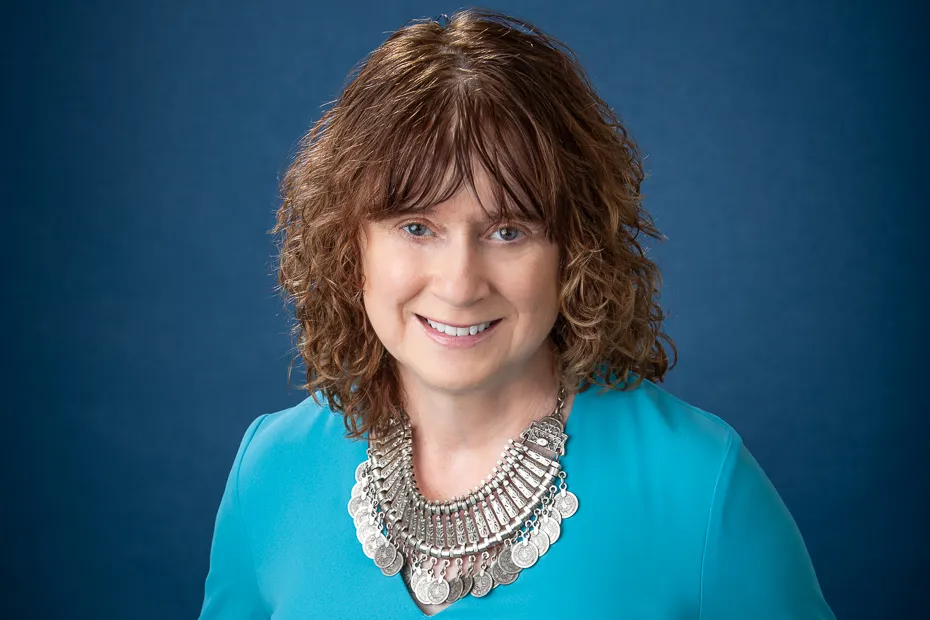 Ann Marvin, change management and AI adoption expert — smiling woman with curly brown hair and blue eyes wearing a turquoise top.